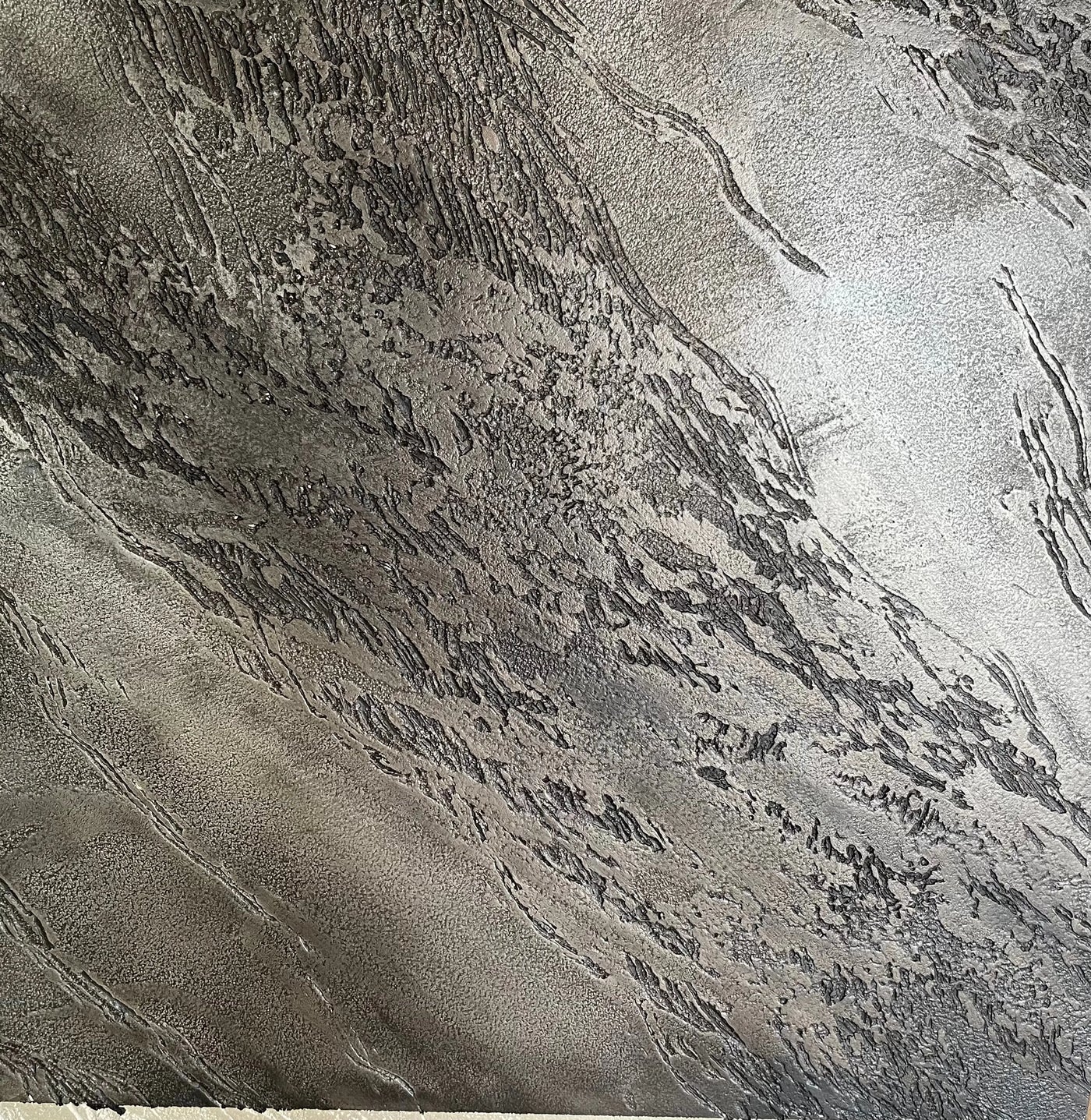 Detalle de textura Istinto Pietra Spaccata de Giorgio Graesan, acabado artesanal con relieve en piedra natural.