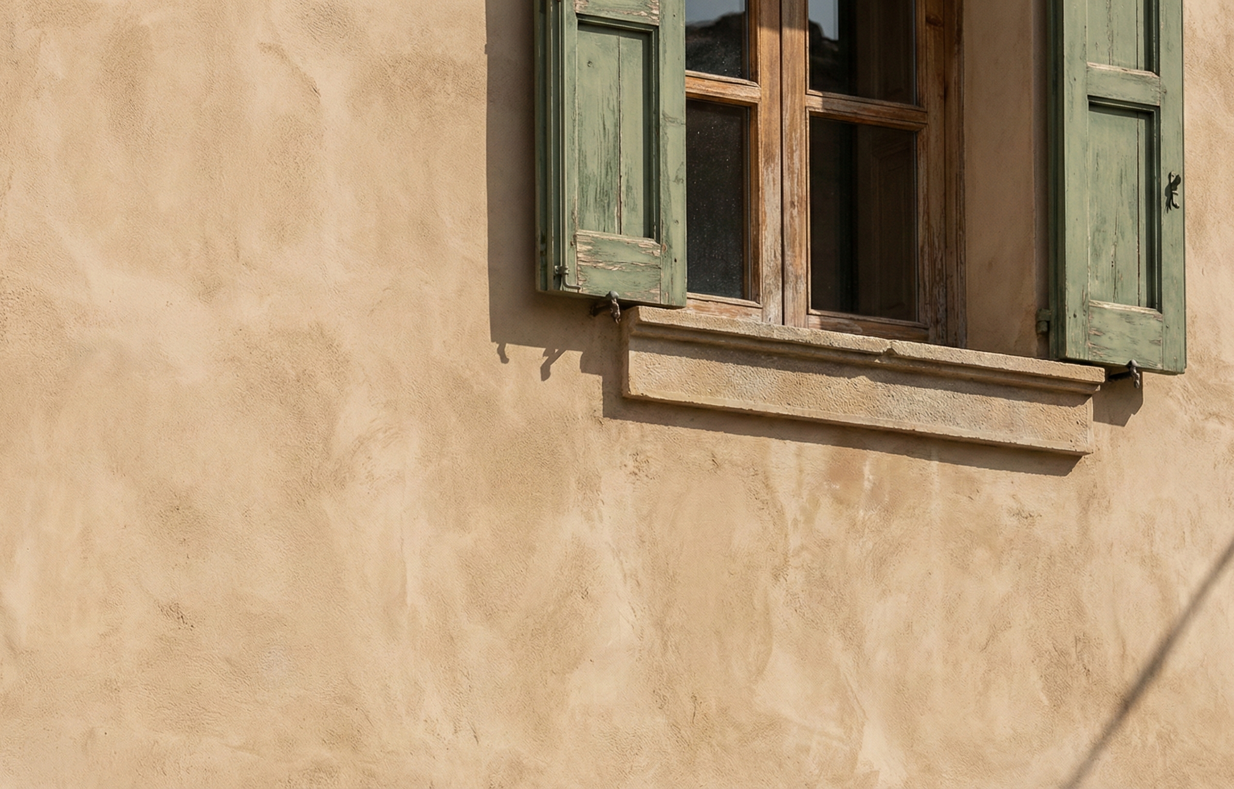 Detalle de fachada exterior revestida con cal, mostrando la textura natural del material y su integración perfecta con elementos arquitectónicos como ventanas.